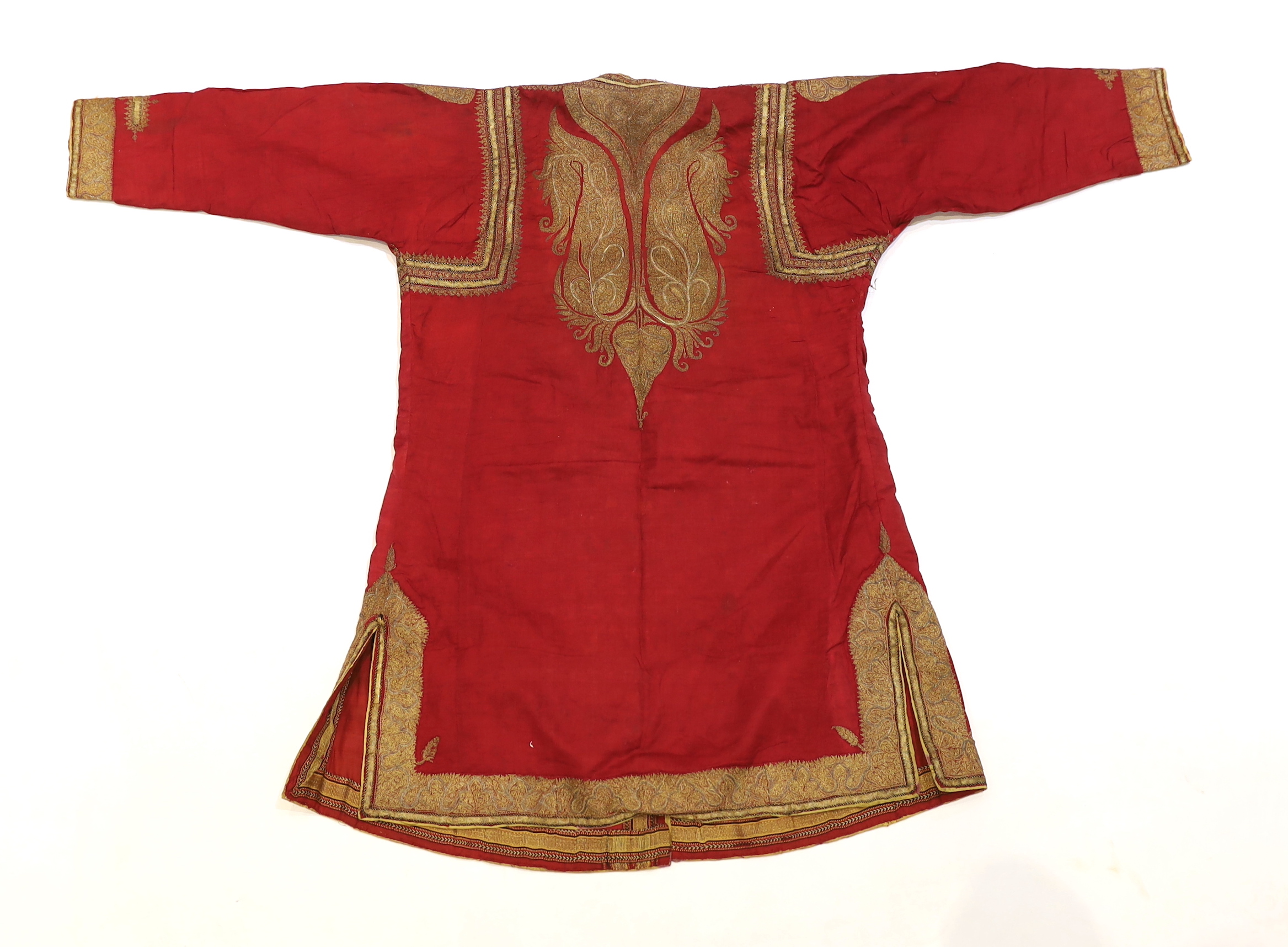 A late 19th century gentleman’s quilted red silk Indian Chogha, embroidered with ornate gold and silver metallic thread borders and paisley design details